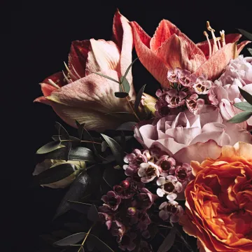 Bukett med blommor i färgerna rosa, vit och orange. 