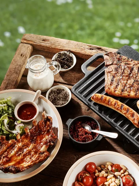 Grillbuffé med sallad, kryddor och kött.